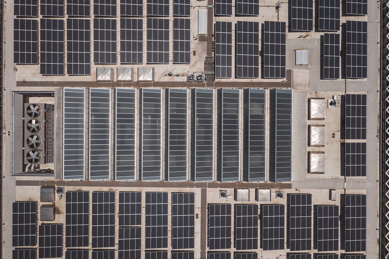 High-angle drone shot of rooftop solar panels showcasing renewable energy technology.